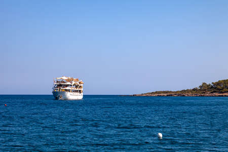 Big cruise ship with tourists sailing in the sea in the hot summer day. Tourism and travel.