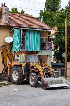 Yellow excavator, bulldozer and working tractor. Road works in the city center. Road equipment on...