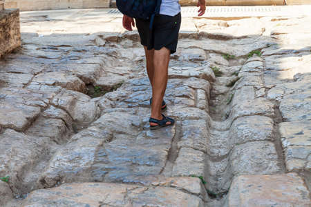 An ancient road and tourists legs going under the hadrian gate in the old city of antalya in turkey...