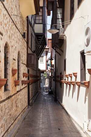 Narrow street and close up view of the wall in old town with beautiful old ancient stone houses and ancient candlesticks or flower beds.の写真素材