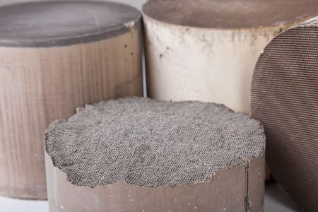 Recycle and purchase of precious non-ferrous metals. Close up on inside parts of broken ceramic catalysts containing platinum, palladium and rhodium on a white background.の写真素材