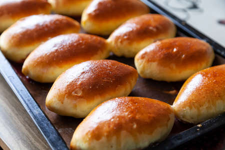 Russian meat piroshki. Traditional hand mini pies on wooden background. Rustic style, closeup view. Russian traditional patties usually made by grandmothers.の写真素材