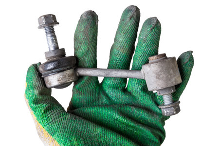 Close-up of a silent block on a used aluminum suspension with fasteners, spare parts for sale during junk yard or for replacement during car service in arm with glove.の写真素材
