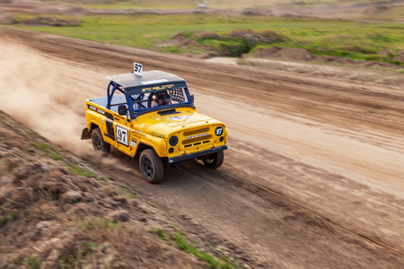 Novosibirsk, Russia - 08.07.2022: Rally off-road car make a turn with the clouds and splashes of sand, gravel and dust during rally championshipのeditorial素材