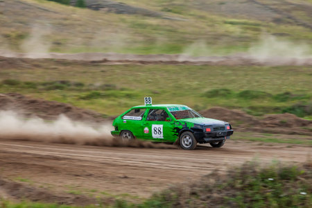 Novosibirsk, Russia - 08.07.2022: Rally off-road car make a turn with the clouds and splashes of sand, gravel and dust during rally championshipのeditorial素材