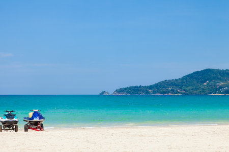 Beautiful Patong beach in Phuket, Thailand with white sand, turquoise water, jet skis and palm treesの写真素材