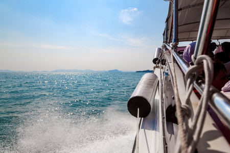 Waves from a speedboat on the blue sea with splashes and a trail from a boat or yacht. The concept of travel and voyage while on vacation in hot Asian countries.の写真素材