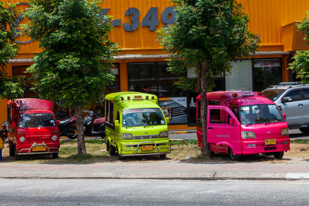 Thailand, Patong - 03.27.23: small Japanese trucks converted into taxis for tourists called tuk tuk in Thailand on the island of Phuket. Multi-colored cars on the streets of the city.のeditorial素材