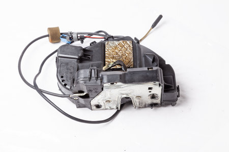 Detail of a car spare part made of black plastic and metal - door lock separately isolated on a...
