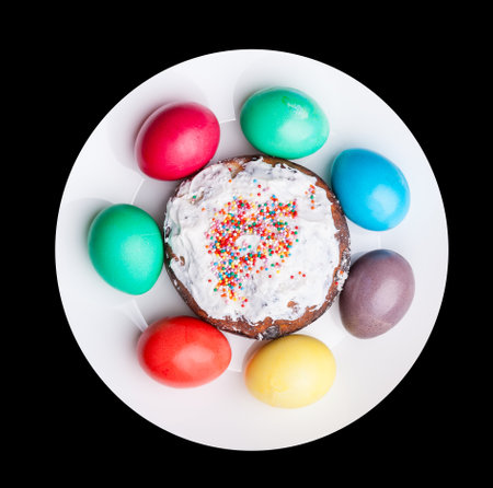 Easter holiday with colorful eggs and Easter cake on a plate while cooking. Homemade cakes in the...