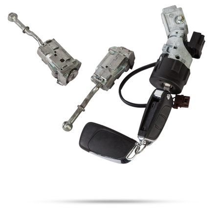 Electronic ignition lock with a key and a button made of black plastic on a white isolated background in a photography studio, a spare part for car repair or for sale in junk yard.の写真素材