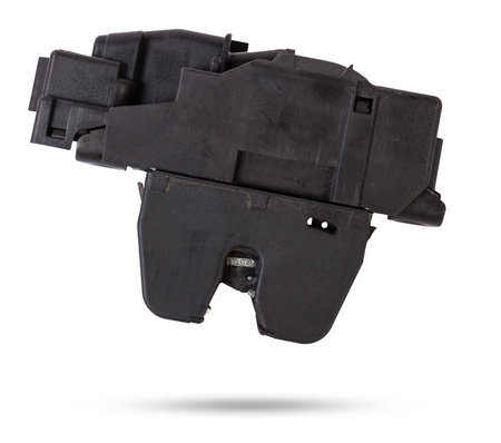 Detail of a car spare part made of black plastic and metal - rear trunk lock separately isolated on a white background. Repair in a car workshop, equipment for sale.の写真素材
