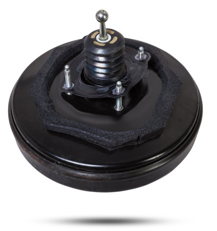 Black metal vacuum brake booster for repair and replacement on a car in a workshop on a white isolated background. Spare parts catalog for cars.の写真素材