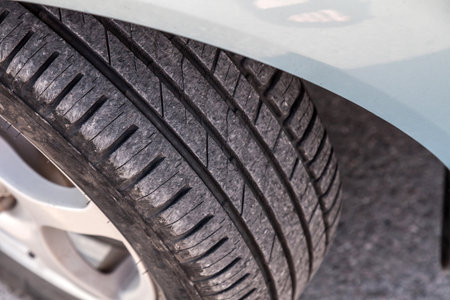 Summer tire with black tread on a silver car for replacement and sale in the garage. Spare parts for...