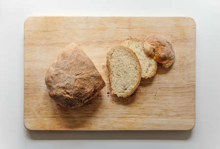 Loaf of white sliced bread on a wooden board on a white backgroundの写真素材