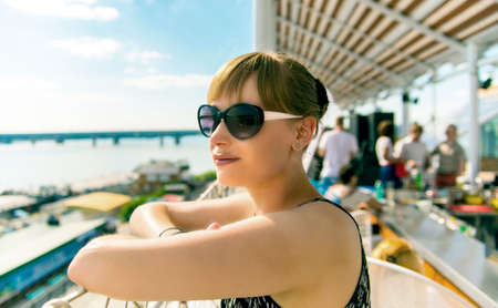 Girl in sunglasses standing and smiling on a sunny summer dayの写真素材