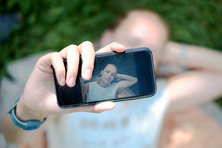 The girl photographed themselves on the green grassの写真素材
