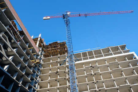 Construction cranes blue and yellow on a background of blue sky