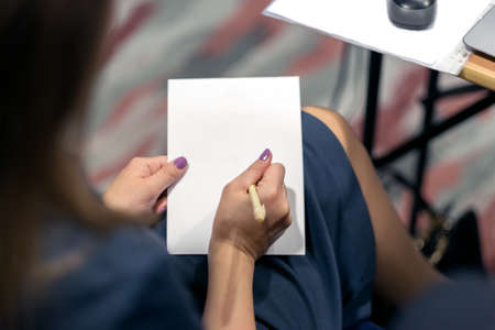 The girl writer on a white sheet of paper on a daylightの写真素材