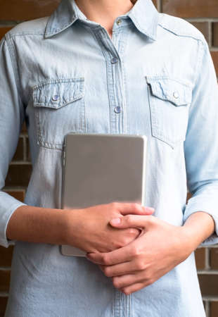 Girl holds an aluminum tablet computer in the daytimeの写真素材