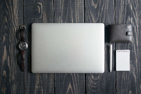 Workplace with a open laptop on a dark wooden tableの写真素材