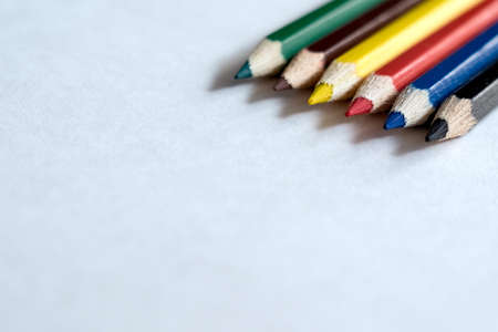 Colored pencils on white paper in daylightの写真素材