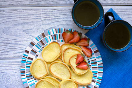 Pancakes strawberries and coffee on a white backgroundの写真素材