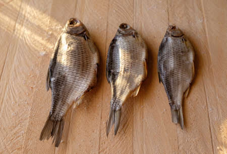 Dried fish on a wooden background in daytime