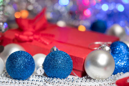 Glass Christmas balls red gift box and garland on a white background. New Year. Christmas balls decoration stocking and toys. Gift box with red bow.の写真素材
