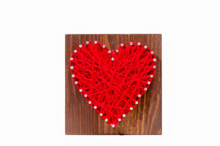 Panel of heart shaped made of thread and nails on white background. Valentine day. String art. Wooden materialの写真素材