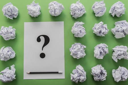 crumpled paper balls and sheet of paper with question-markの写真素材