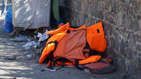 Abandoned belongings and life jackets on the shore
