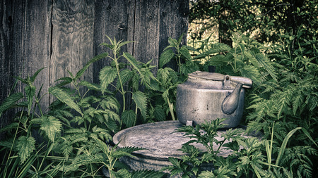 Old teapot on the street on a background of a wooden wallの写真素材