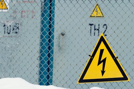 A protective network and signs warning of the danger of electric shocksの写真素材
