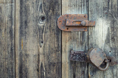 Old wooden door locked on padlockの写真素材