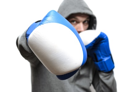 Boxer in large combat gloves and a sports jacket with a hoodの写真素材