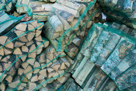 chopped firewood for home heating, collected in mesh bagsの写真素材