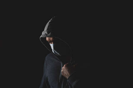 man in a medical mask on a black background, protection against coronavirus, disease prevention