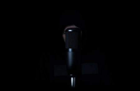 the guy sings into a condenser microphone on a dark backgroundの写真素材