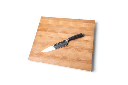 a large sharp kitchen knife on a large wooden board on a white backgroundの写真素材