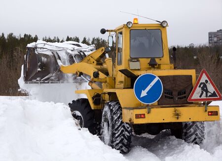 The tractor clears snow from the road blockage  Heavy special technique  