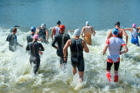 Triathlon Cup of Ukraine and Cup of Bila Tserkva. July 24, 2016 in Bila Tserkva. Group triathlon participants running into the water for swim portion of race. Splash of water and athletes running.のeditorial素材