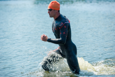 Triathlon Cup of Ukraine and Cup of Bila TserkvaTriathlon Cup of Ukraine and Cup of Bila Tserkva. July 24, 2016 in Bila Tserkva.Triathlete running out of the water on triathlon race.のeditorial素材