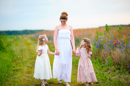 Happy mom with kids walking near the spring fieldの写真素材