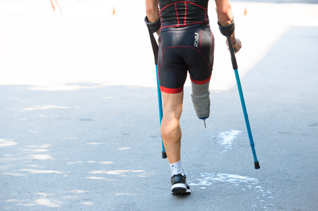 Triathlon Cup of Ukraine and Cup of Bila Tserkva. July 24, 2016 in Bila Tserkva, Ukraine. Paralympic disabled man athlete on crutchのeditorial素材