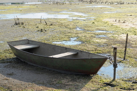 drought in the hot summer. Dried river without water and boatの写真素材