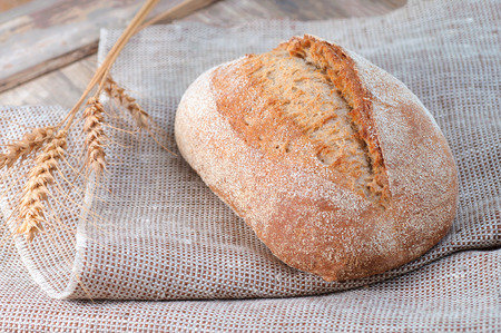 fresh loaf of bread on a linen napkin, food on vintage tableの写真素材