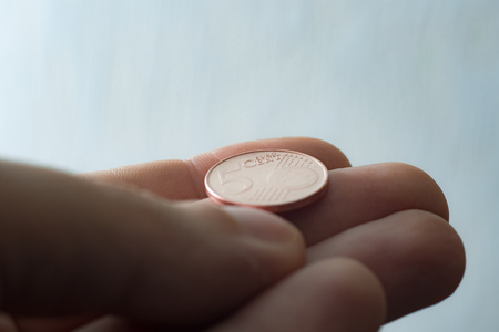 Euro coin on finger tips