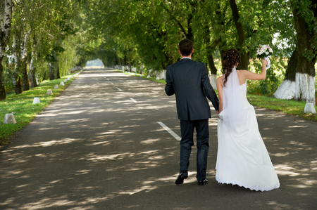 Happy newlywed couple dancing at the roadの写真素材
