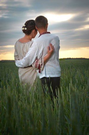 young embracing couple is watching the sunset の写真素材